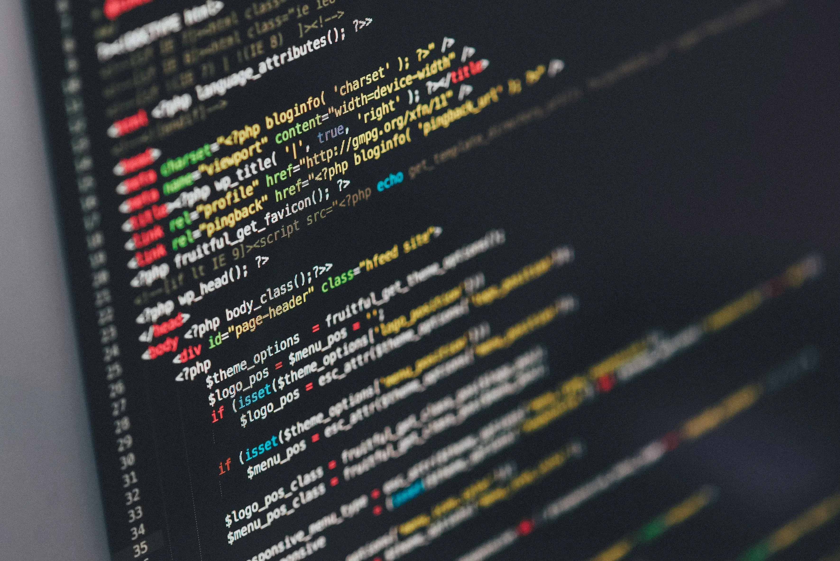 Laptop showing a code editor at a desk